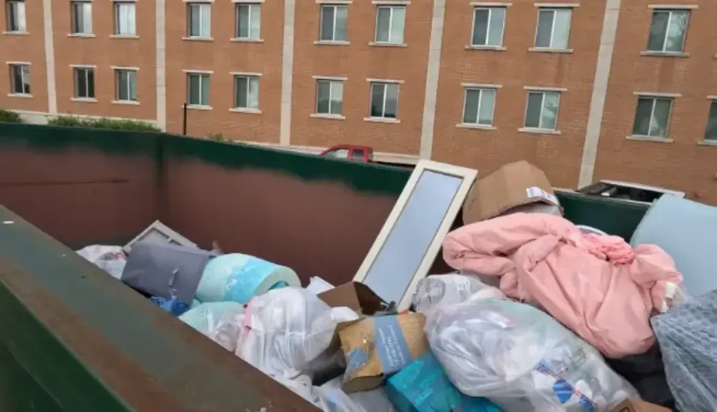 Estate cleanout dumpster filled with household items at a Fresno apartment